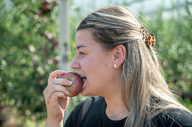 istock A girl bites a fresh apple . 2254440687