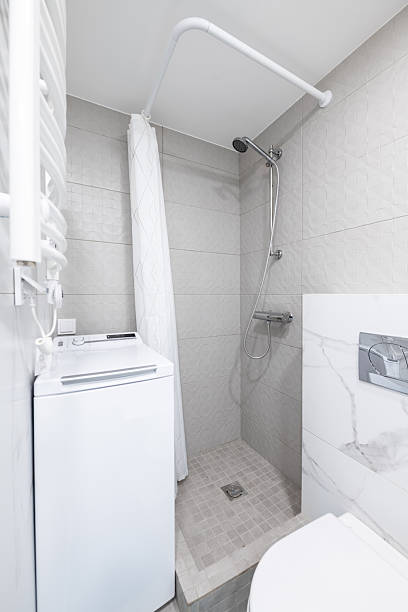 istock Compact Bathroom Interior with Laundry Unit and Shower Area 2254441123