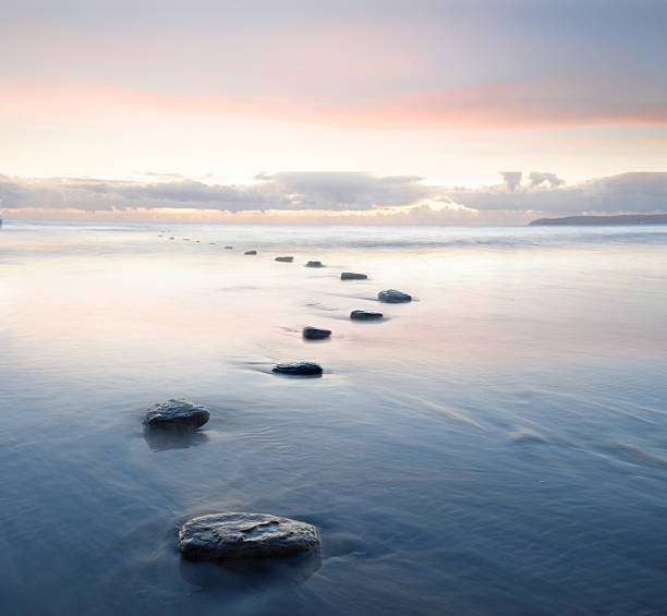 View down stepping stones and tidal water at dusk
