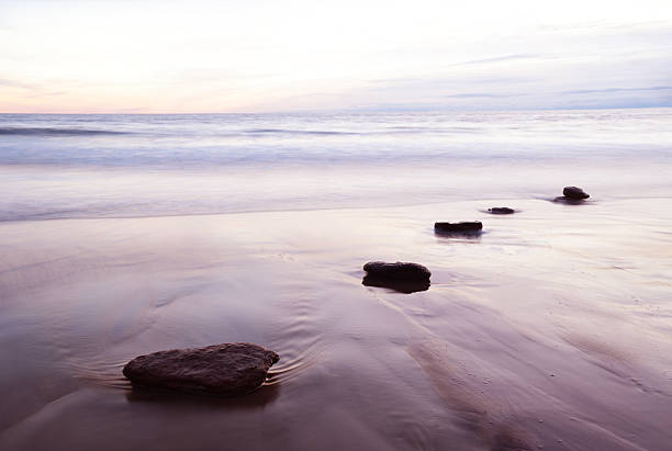 View down stepping stones and tidal water at dusk