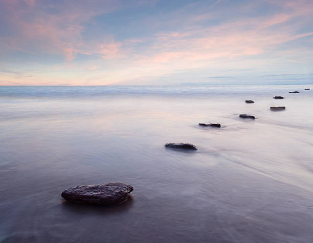 View down stepping stones and tidal water at dusk