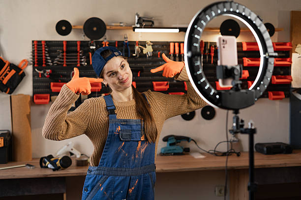 istock Craftsman or artisan blogger with ring light and smartphone streaming in workshop with assortment tools pointing with fingers on good smile. Blogging, industry and technology 2254441768