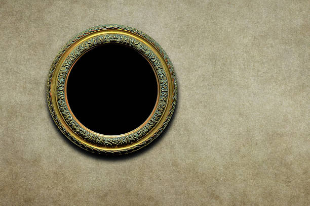 This elegant vintage circular frame features intricate floral carvings and a distressed gold finish, set against a warm textured wall that provides ample copy space for creative designs, making it ideal for displaying classic portraits, historical announcements, or sophisticated branding elements.