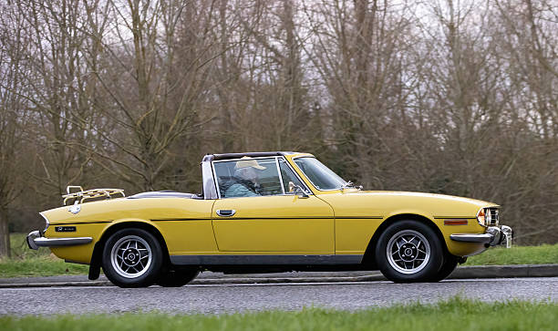 Milton Keynes,Bucks,UK - Jan 1st 2026: 1974 yellow Triumph Stag  classic car driving on a British road