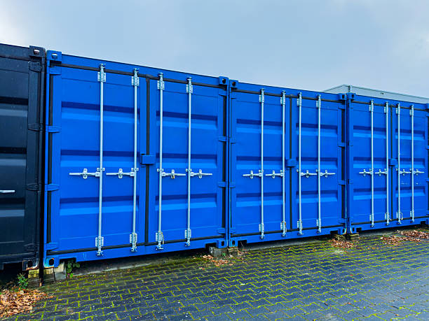 istock Bright blue shipping containers lined up against a grey sky in a storage yard on an overcast day 2254444518