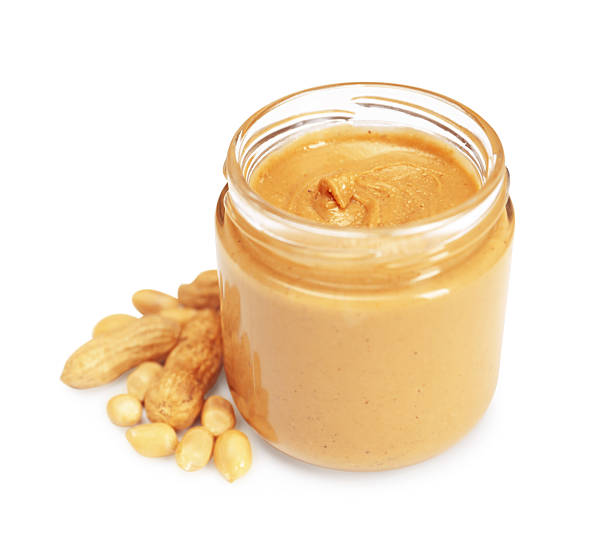 istock Tasty nut paste in jar and peanuts isolated on white 2254446335