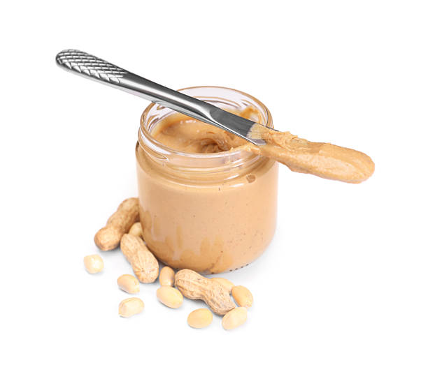 istock Tasty nut paste in jar, knife and peanuts isolated on white 2254446372