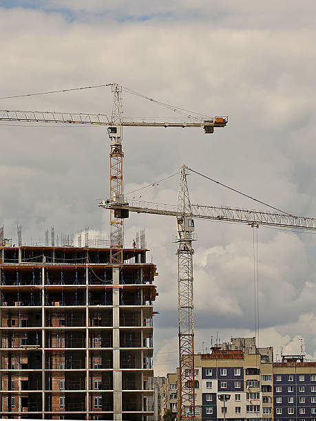istock Tower cranes work during the construction of a multi-story building. New apartments for residents and premises for offices. Risky work at height. Lifting heavy building materials. City development 2254448228