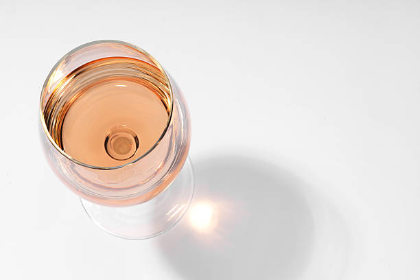 istock Rose wine in glass and shadow on white background, top view. Space for text 2254448840