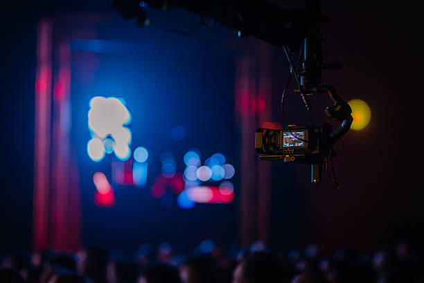 istock Camera mounted on a crane captures vibrant stage performance with colorful lights and blurred audience in the foreground, showcasing the excitement of live entertainment 2254451123
