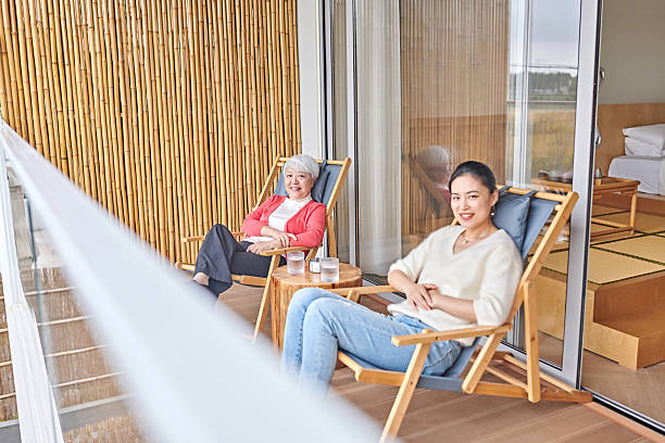 istock Two Asian Women Discussing while Drinking Water at Balcony 2254451263