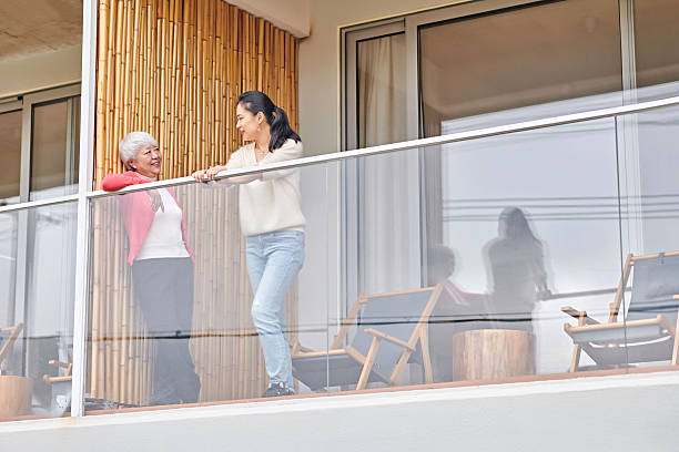 istock Two Asian Women Discussing while Looking View at Balcony 2254451400