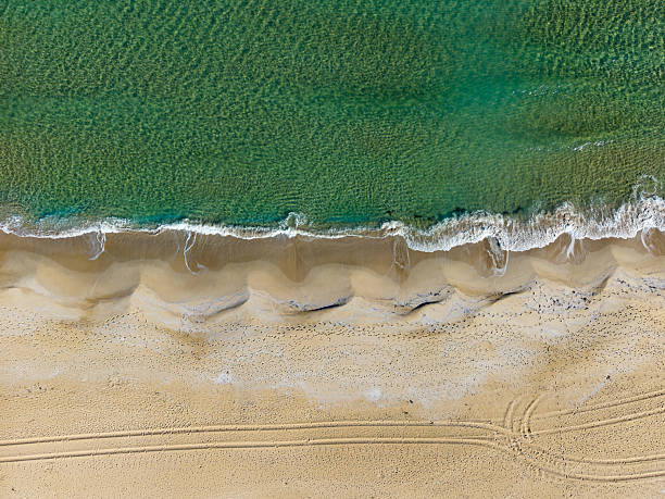 istock Waves gently crashing on a sandy shore under bright sun in an idyllic coastal landscape perfect for relaxation and leisure 2254452423