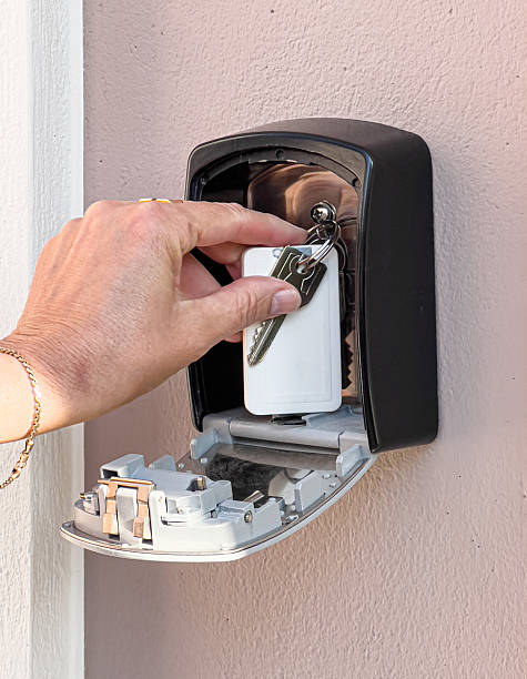 istock Hand placing keys into secure outdoor key safe box 2254453879