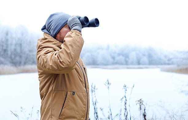 istock Ecologist man with binoculars observing the frozen winter forest. 2254456226