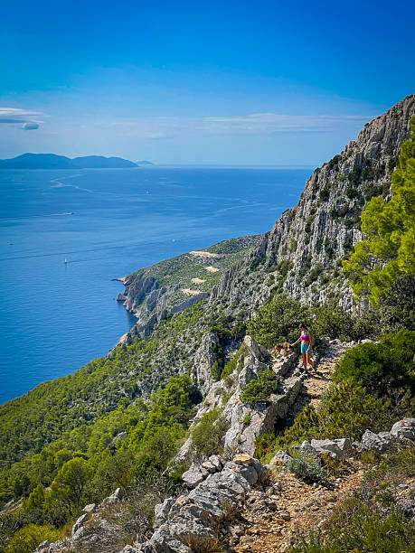 istock Hiker with her loyal dog walks along a rugged path overlooking Adriatic Sea 2254456997