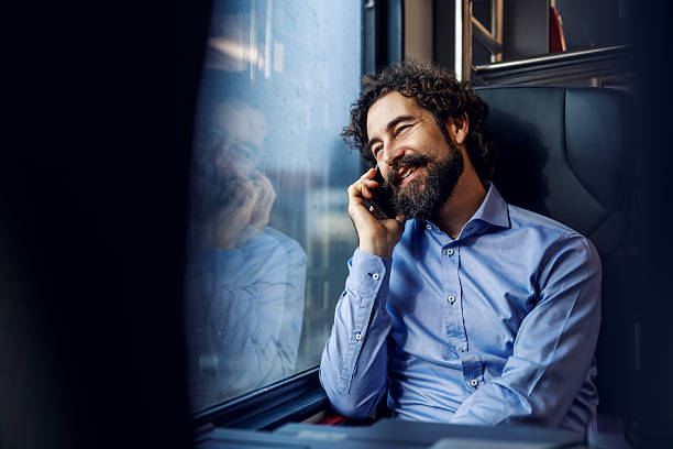 istock Smiling man talking on smartphone while traveling by train 2254457670