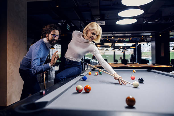 istock Happy couple enjoying night out playing pool 2254458491