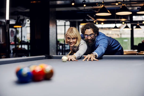 istock Happy couple playing billiards on a date night 2254458549