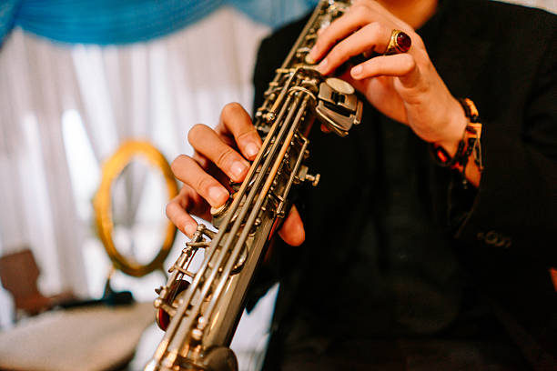 istock Musician's hands expertly playing a shiny brass saxophone 2254461717