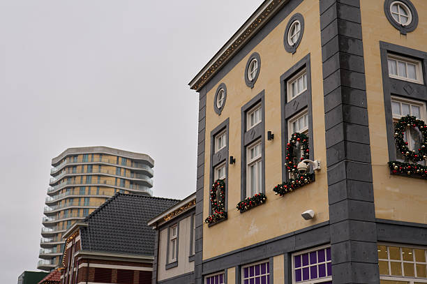 Historic building decorated with christmas wreaths contrasting a modern high-rise in the city