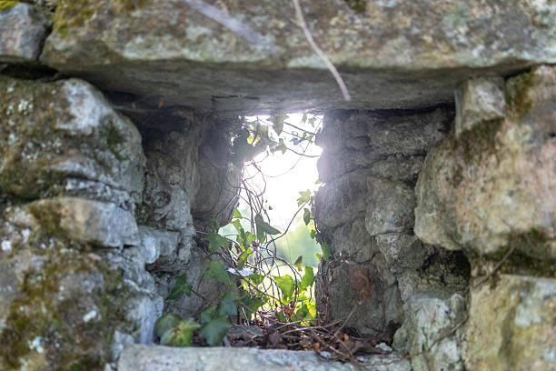 istock A small window or loophole in mossy stones 2254467534