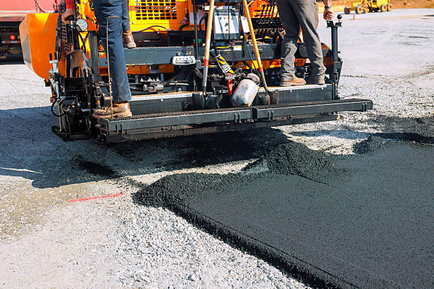 istock Asphalt paving machine laying down fresh asphalt at construction road site 2254469239