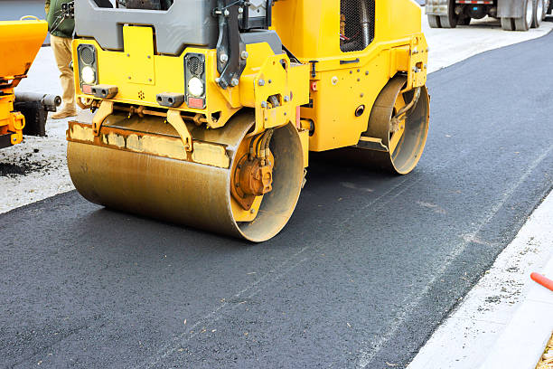 istock Road construction crew uses heavy roller to compact asphalt on new road surface 2254469247
