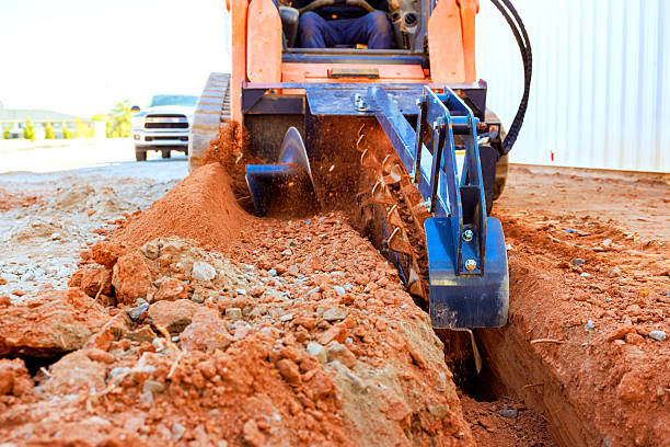 istock Construction worker uses trenching machine to dig trench in ground job site 2254469289
