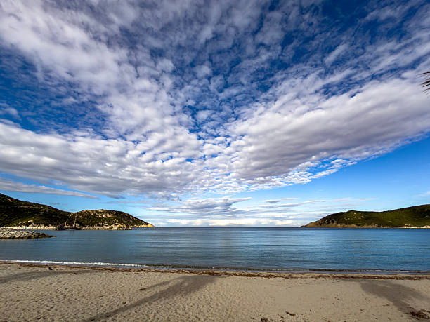 istock Blue and White Flowing Clouds Over Beach – Serene Coastal Photography 2254470127