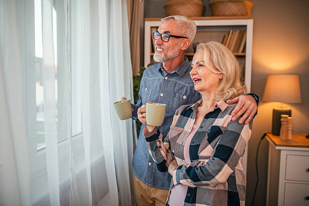 istock Mature couple drinking coffee by the window at home 2254477493