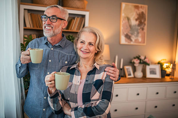 istock Happy senior couple drinking coffee by the window at home 2254477708