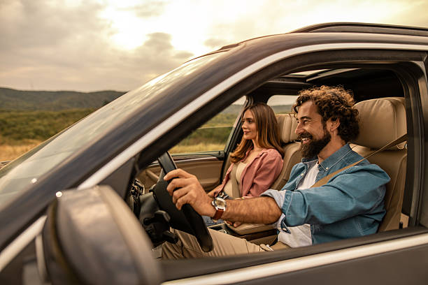 istock Couple driving car enjoying road trip during sunset 2254492004