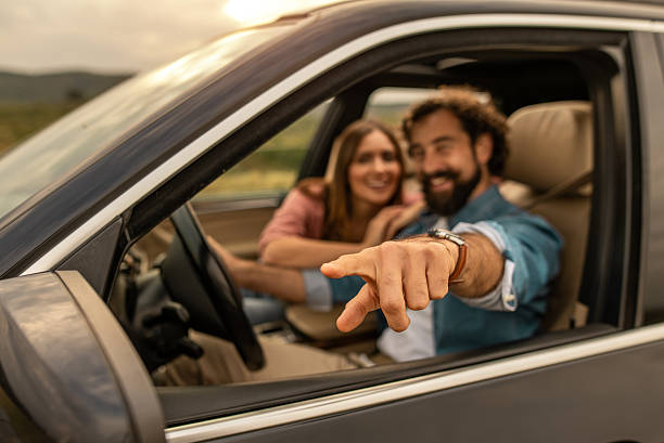 istock Happy couple pointing finger on road trip 2254493924