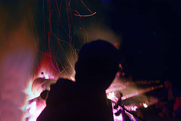 istock Huge fire at night and young people around. 2254499963