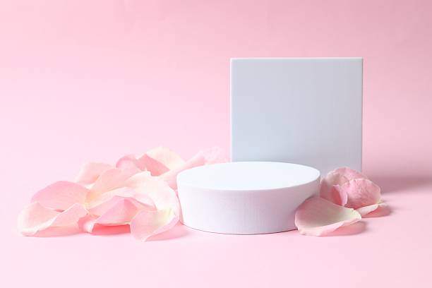 istock Pink rose petals with podium on color  background 2254501546