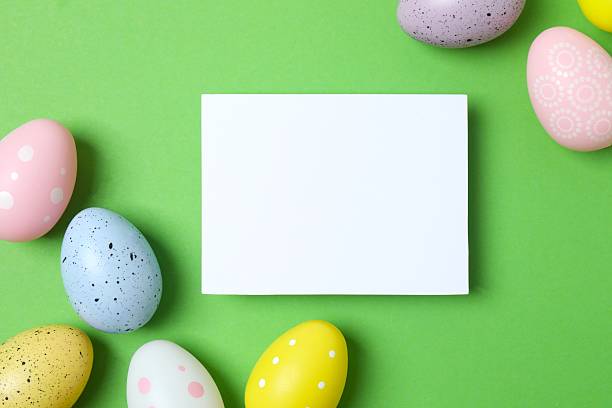 istock Happy Easter. Colorful eggs with white paper card on color background, space for text or advertising 2254502487