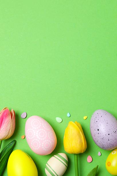 istock Happy Easter. Colorful eggs with tulips on green background, space for text or advertising 2254502505