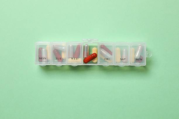 istock Daily pill box with medications on color background, top view 2254502739