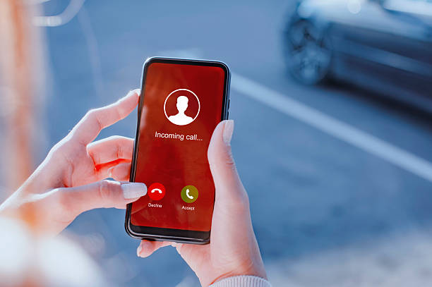 istock Woman hand with painted nails is seen using a smartphone to either Accept or Decline an incoming call on an urban street on a parking. 2254505250