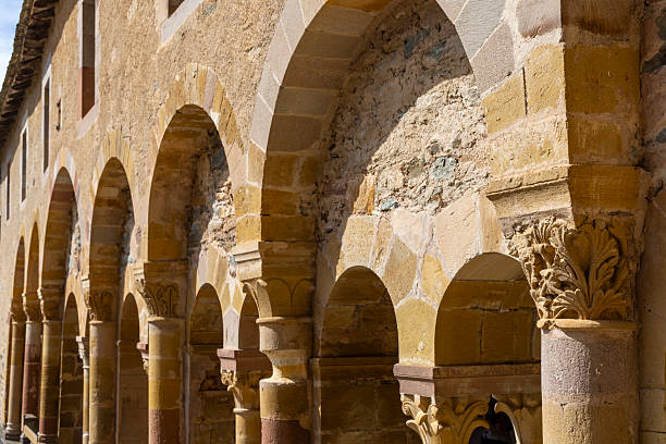Arched cloister columns and capitals illuminated by sunlight in a historic French abbey