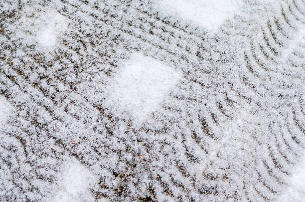 Abstract pattern of fresh white snow on paving stones outdoors.