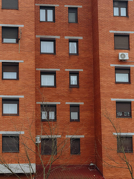 istock Red brick building facade with apartment windows and shutters 2254508295
