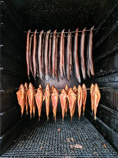 Various fish hanging inside a smokehouse, preparing for consumption