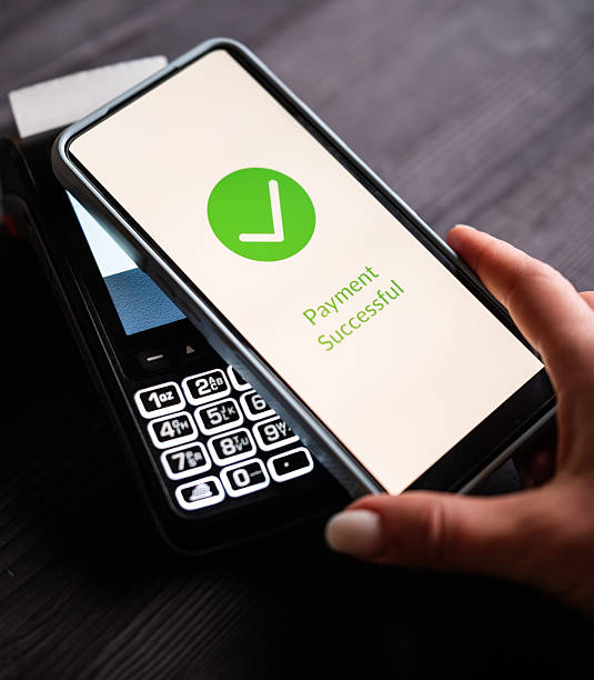 istock Girl Paying With Smartphone Over Wireless Terminal With Payment Approved Status On A Screen 2254515469