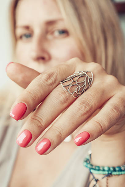 Bride's hand with beautiful diamond ring on white dress stock photo