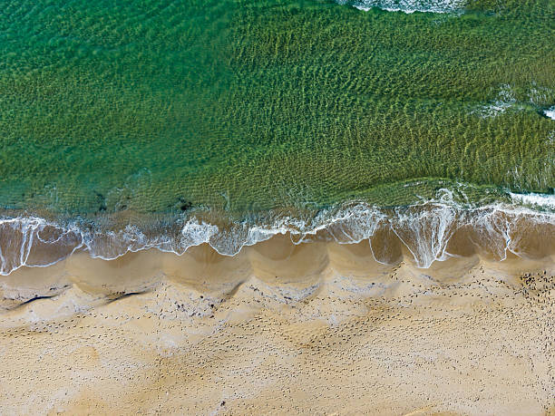 istock Waves gently lapping against a sandy beach under a clear blue sky at midday with vibrant turquoise waters inviting relaxation 2254520799