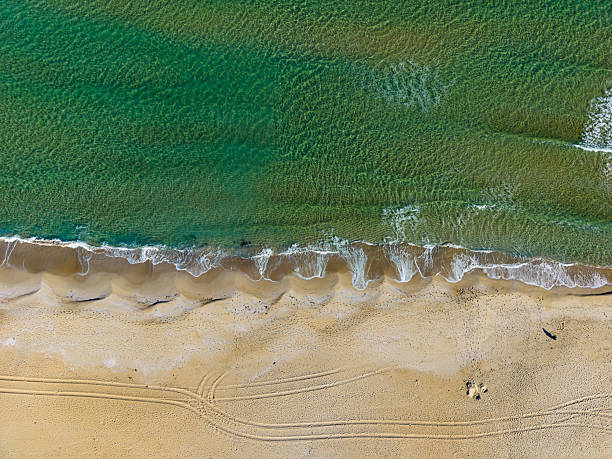 istock Tranquil shoreline at sunset with gentle waves lapping against warm golden sand on a serene beach location 2254520866