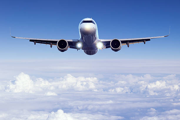 Passenger jet airplane flying above clouds