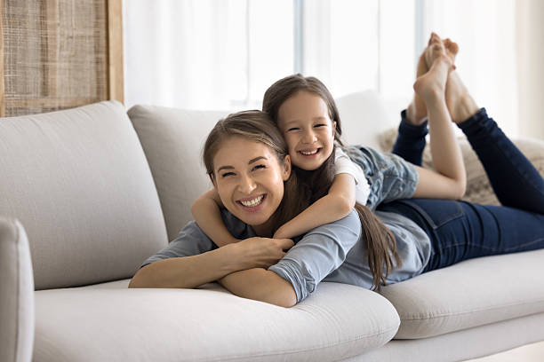 istock Little girl lying on moms back, smile look at camera 2254521052